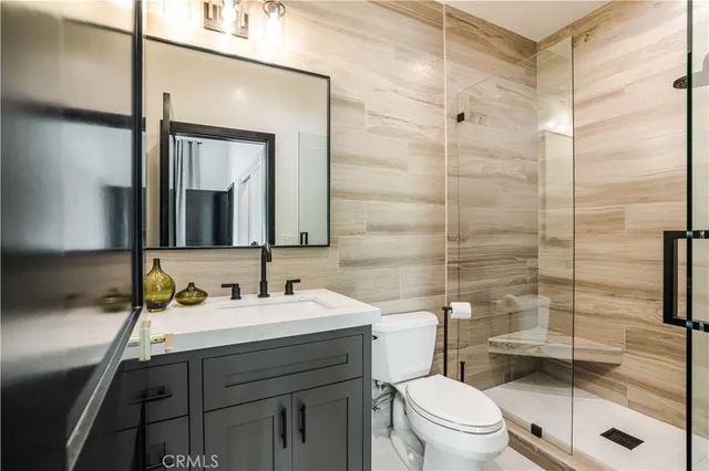 a bathroom with a sink toilet vanity and shower