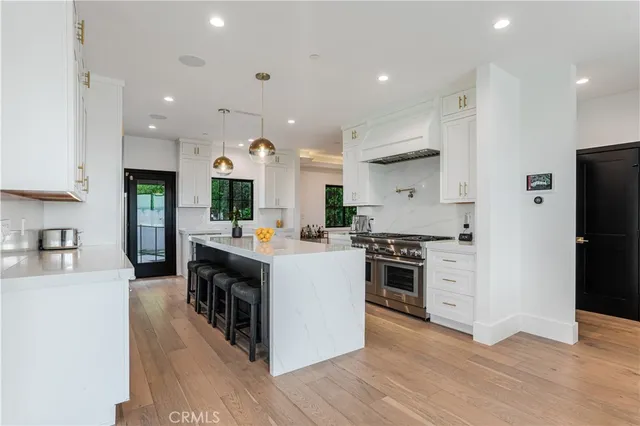 a large kitchen with stainless steel appliances kitchen island a large counter top and a stove top oven