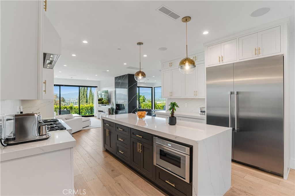 14614 Round Valley Drive Sherman Oaks, CA 91403 - Photo 7 of 35 a kitchen with stainless steel appliances kitchen island granite countertop a sink a stove and a refrigerator