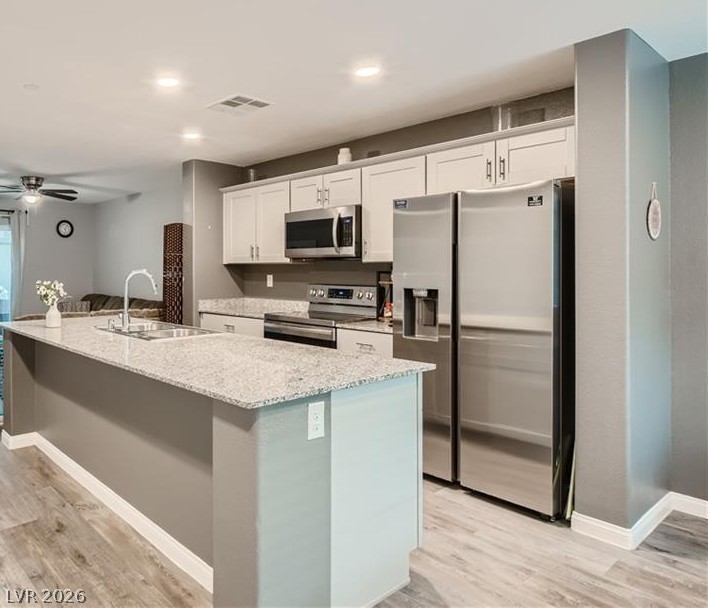 12110 Midnight Pine Road, Unit 3 Las Vegas, NV 89183 - Photo 5 of 13 A contemporary kitchen features an inviting island, perfect for casual dining and meal preparation.