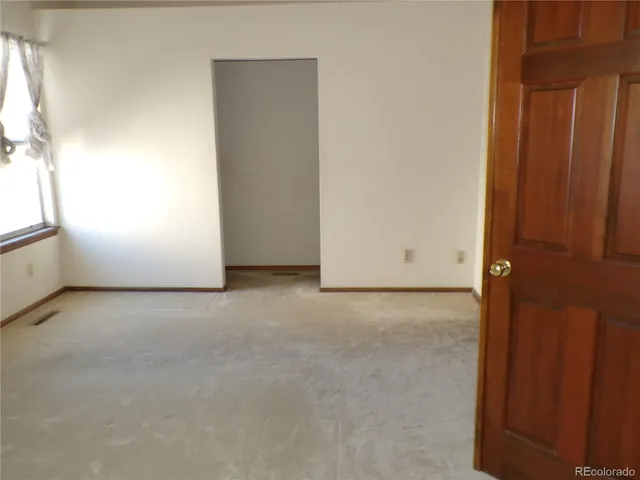 an empty room with windows and fireplace