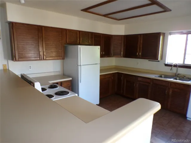 a kitchen with a refrigerator sink and cabinets