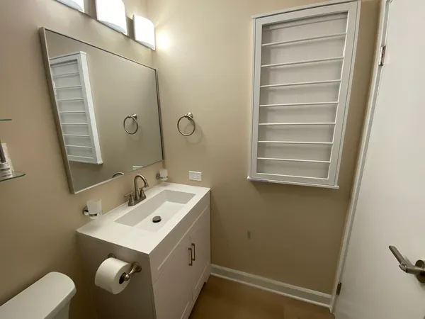 a bathroom with a sink and mirror with toilet