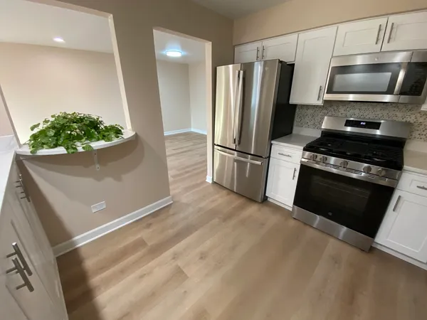 a kitchen with stainless steel appliances a refrigerator a stove a microwave and cabinets