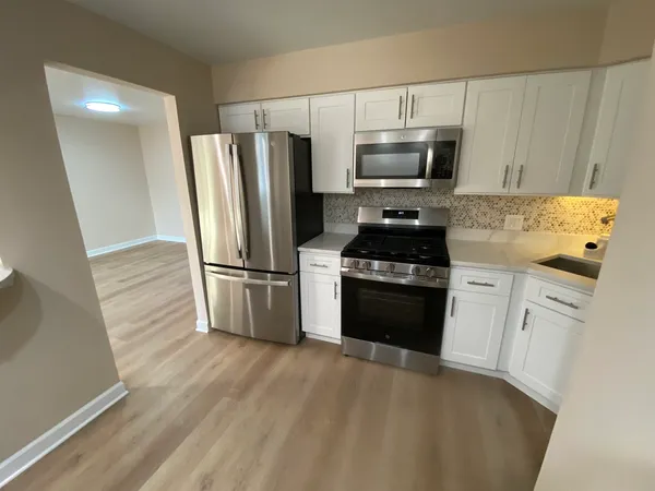 a kitchen with granite countertop a refrigerator stove and microwave