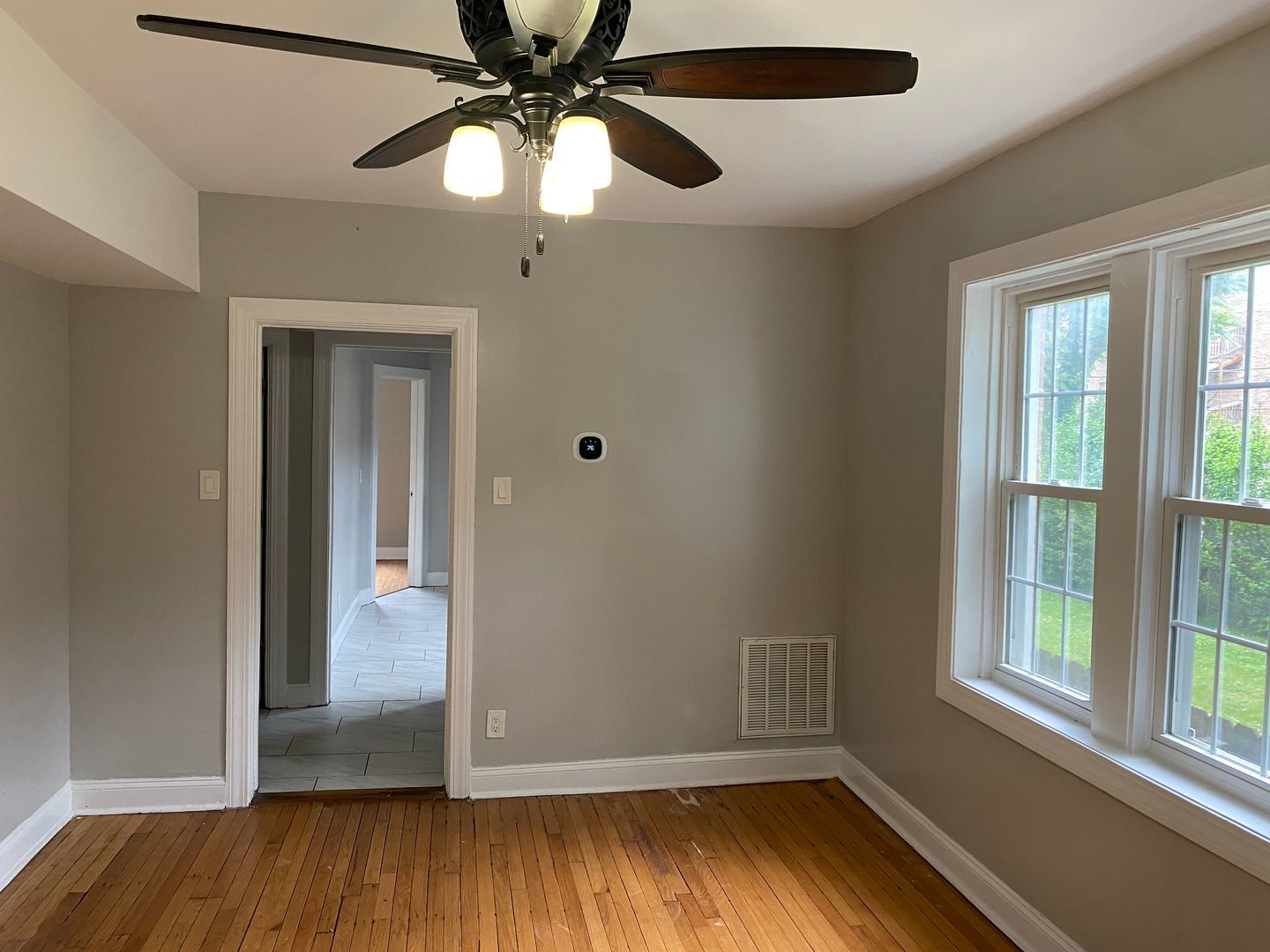 7822 South Kingston Avenue, Unit 1 Chicago, IL 60649 - Photo 14 of 15 wooden floor in an empty room with a window