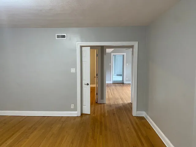 a view of a hallway with wooden floor
