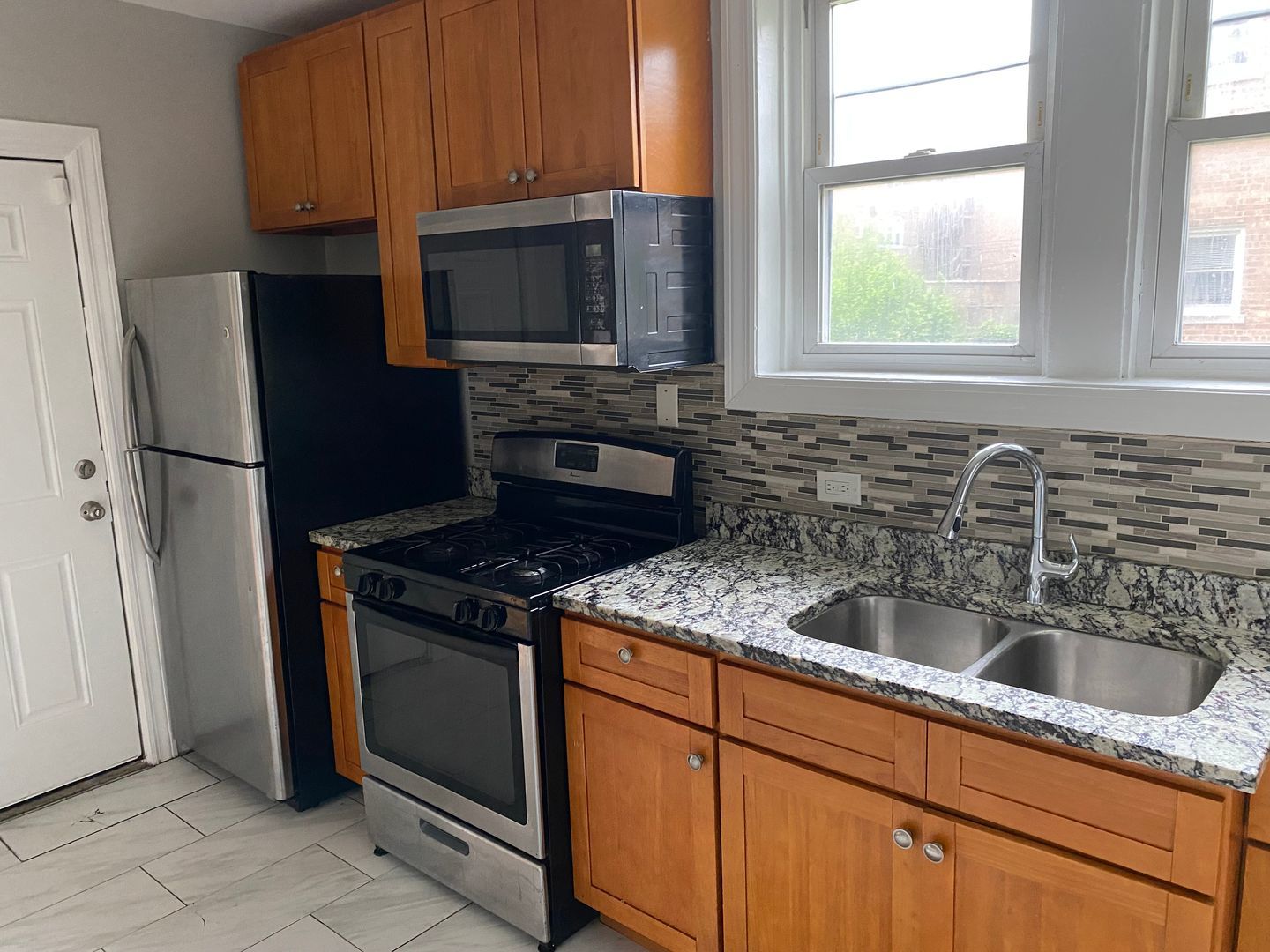 7822 South Kingston Avenue, Unit 1 Chicago, IL 60649 - Photo 7 of 15 a kitchen with granite countertop a sink stove and refrigerator