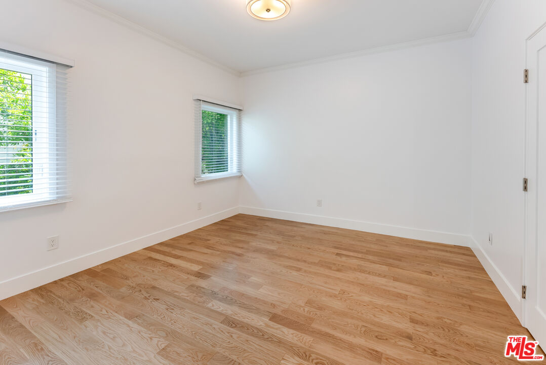 1253 South Rimpau Boulevard Los Angeles, CA 90019 - Photo 68 of 71 an empty room with wooden floor and windows