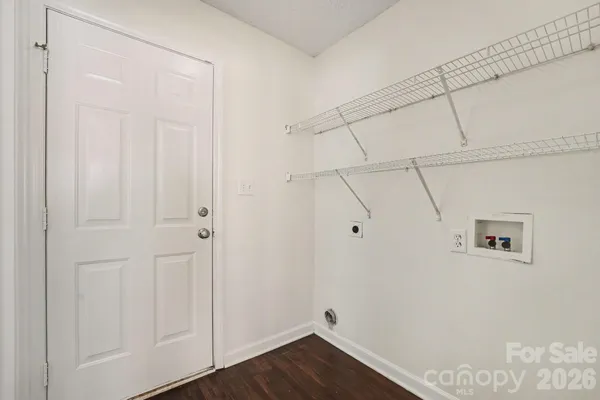 a view of a closet area with wooden floor