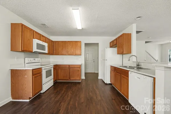 a large kitchen with stainless steel appliances granite countertop a sink stove and wooden floor