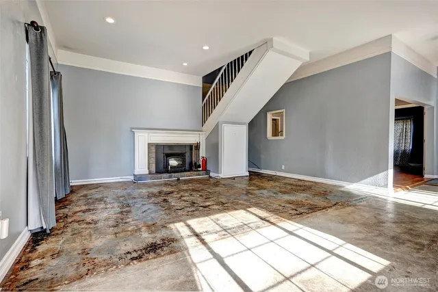 a view of empty room with fireplace and wooden floor