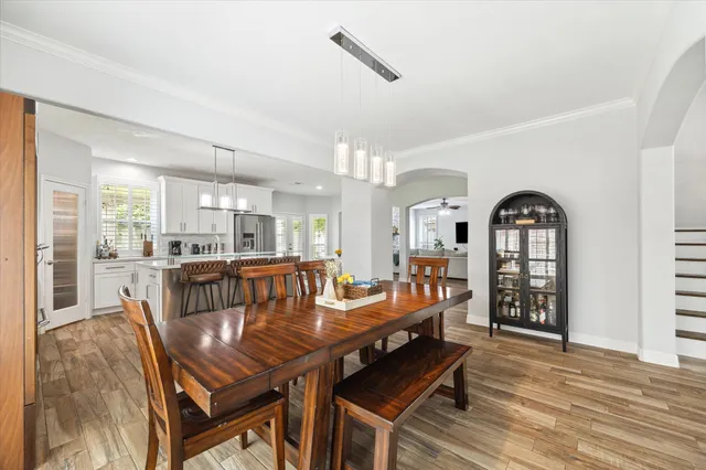 a living room with furniture a dining table and wooden floor