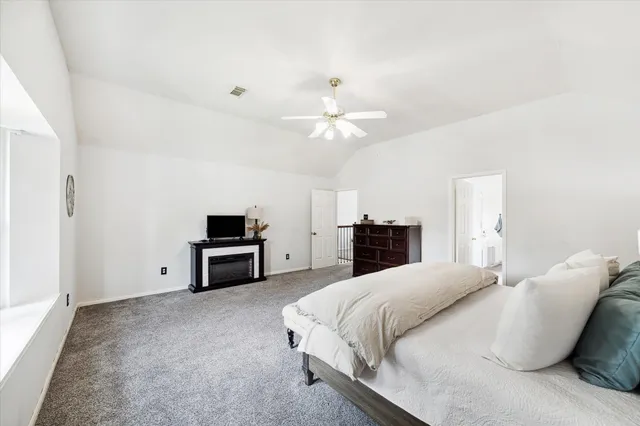 a spacious bedroom with a bed and a ceiling fan