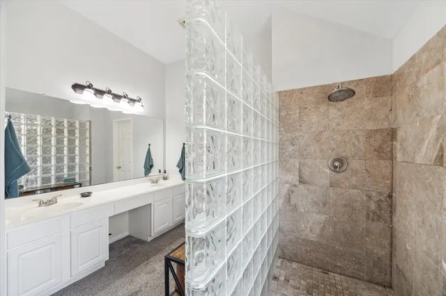 a bathroom with a double vanity sink a large mirror and a bathtub