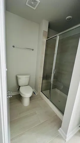 a bathroom with a toilet and a shower