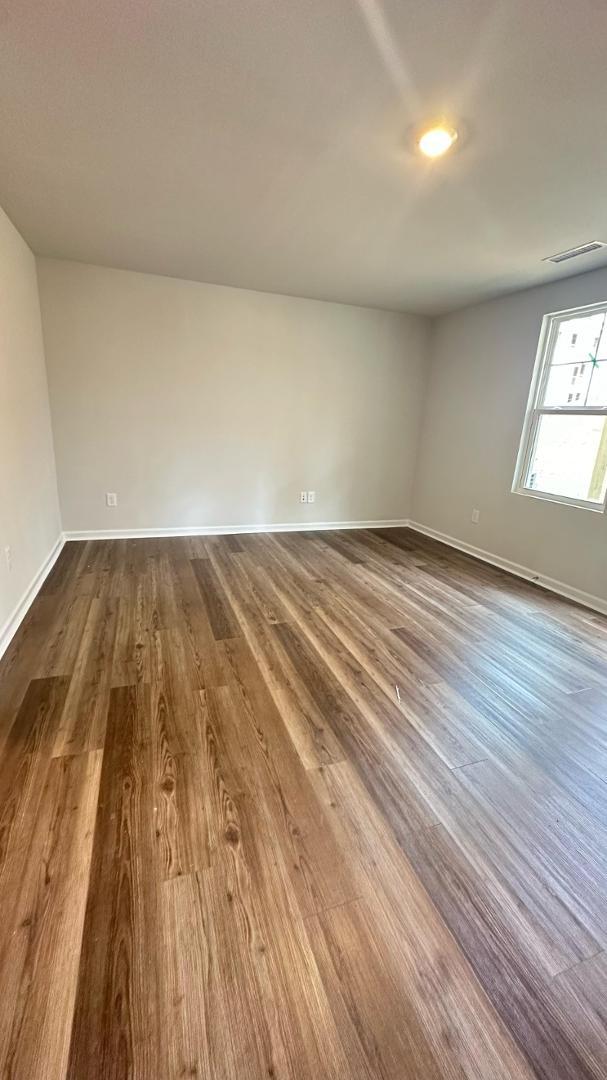 114 Red Brush Way Apex, NC 27539 - Photo 4 of 22 wooden floor in a hall with an empty room
