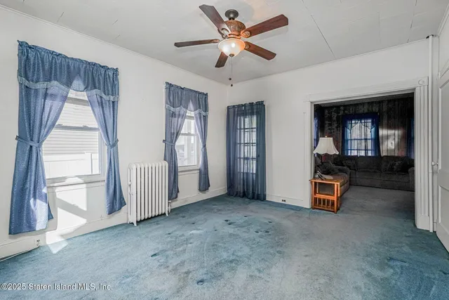 a view of a livingroom with a ceiling fan and window