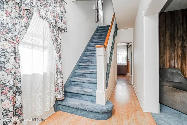 a view of entryway and hall with wooden floor