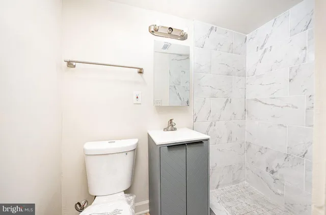 a bathroom with a toilet sink and mirror