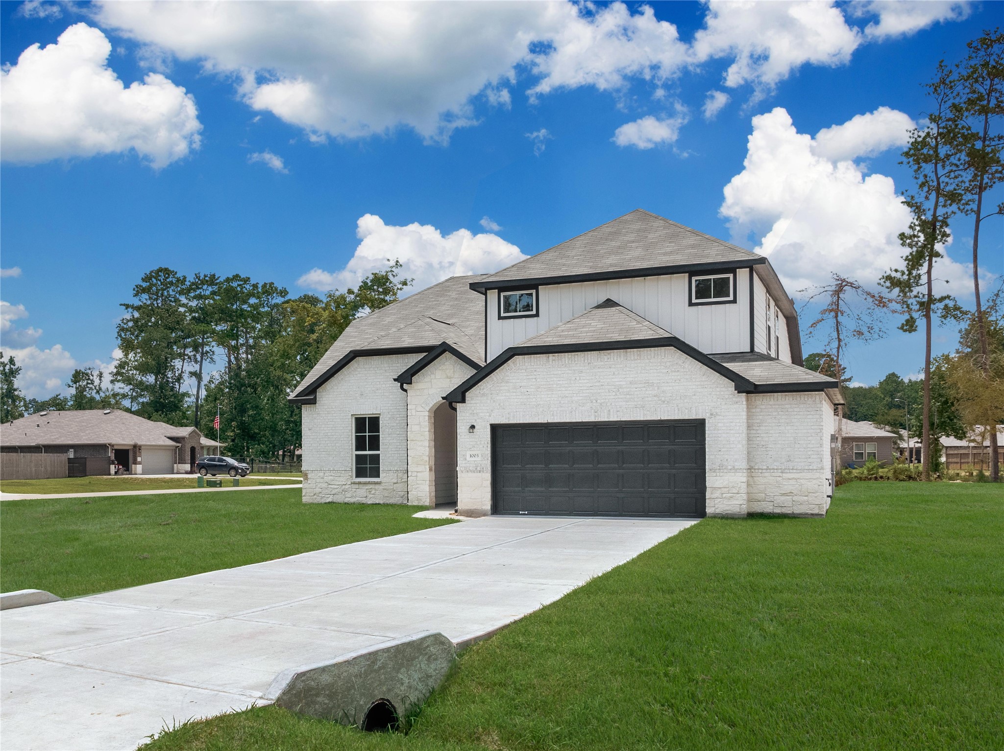 1003 Thor New Caney, TX 77357 - Photo 2 of 45 a front view of a house with a yard and garage