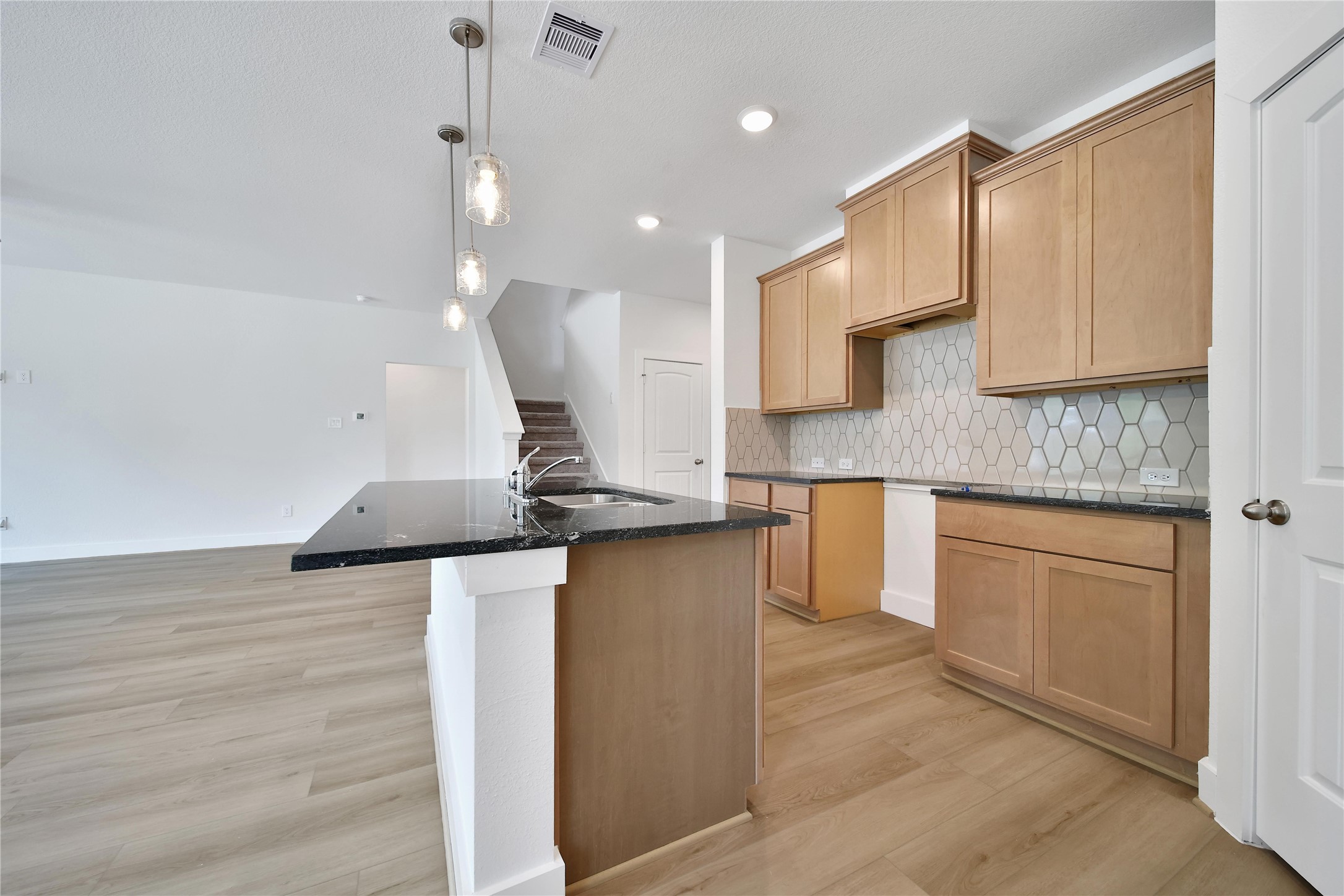 1003 Thor New Caney, TX 77357 - Photo 9 of 45 a kitchen with kitchen island granite countertop a sink a counter space and cabinets