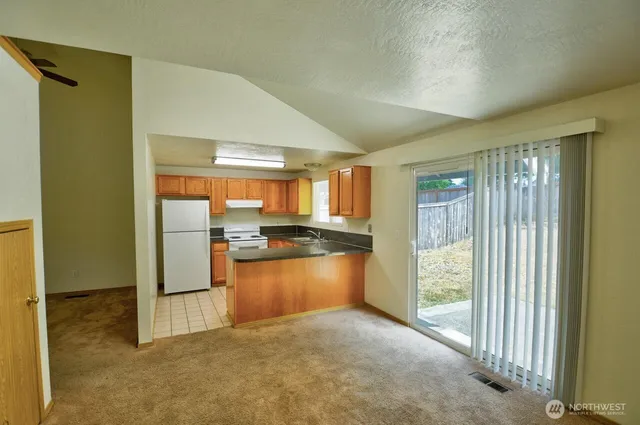 a view of a kitchen with a sink and a refrigerator