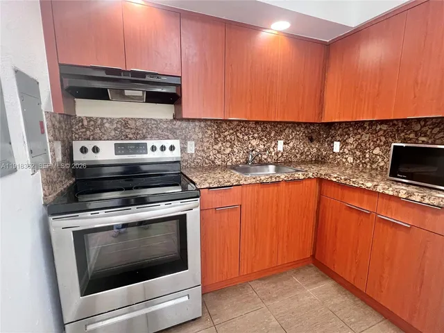 a kitchen with granite countertop stainless steel appliances and cabinets