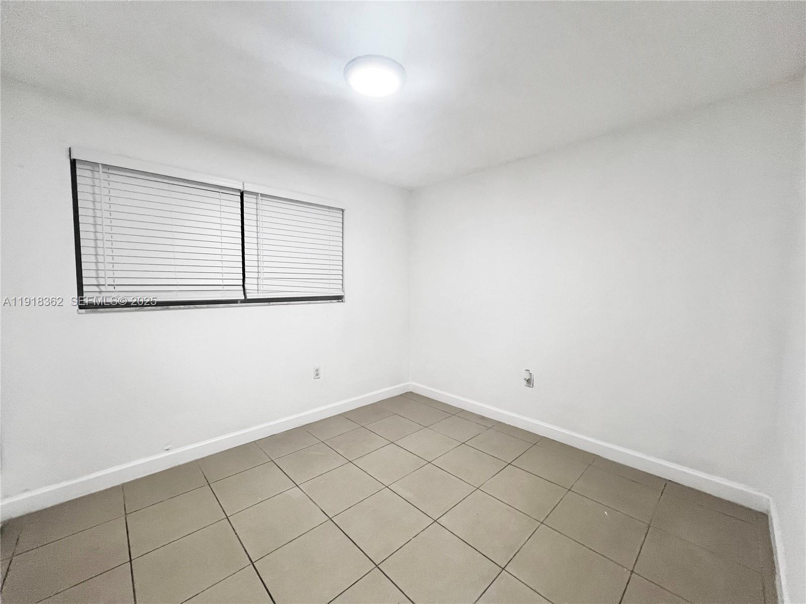 65 Northeast 59th Street, Unit 3 Miami, FL 33137 - Photo 7 of 10 an empty room with a bench