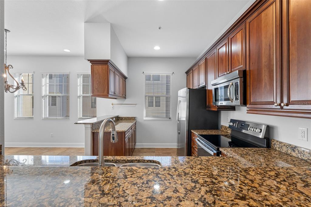 5902 Printery Street, Unit 105 Tampa, FL 33616 - Photo 14 of 54 a kitchen with stainless steel appliances granite countertop a refrigerator stove and oven