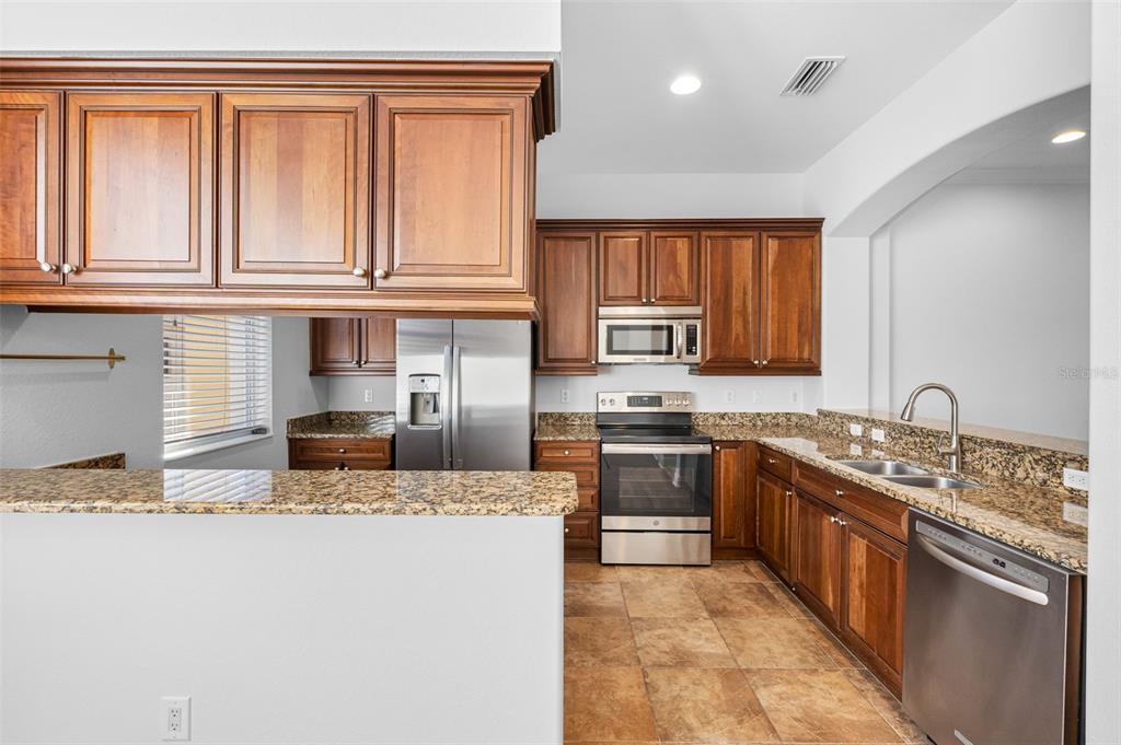 5902 Printery Street, Unit 105 Tampa, FL 33616 - Photo 15 of 54 a kitchen with stainless steel appliances granite countertop a sink stove and granite countertops