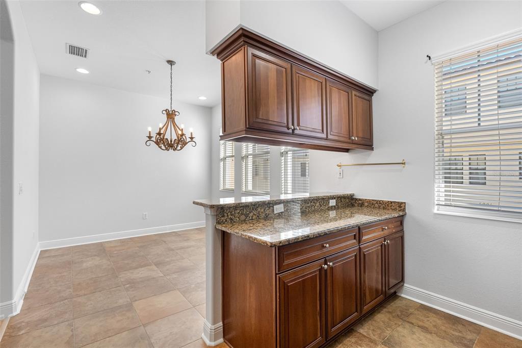 5902 Printery Street, Unit 105 Tampa, FL 33616 - Photo 18 of 54 a kitchen with stainless steel appliances granite countertop a sink a stove and a wooden cabinets
