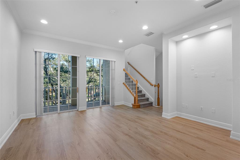 5902 Printery Street, Unit 105 Tampa, FL 33616 - Photo 9 of 54 a view of an empty room with wooden floor and stairs