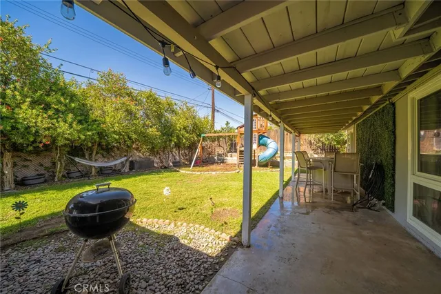 a view of a patio with a table chairs and a grill