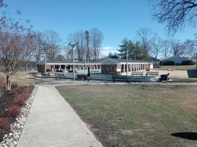 a view of swimming pool with outdoor seating and trees in the background