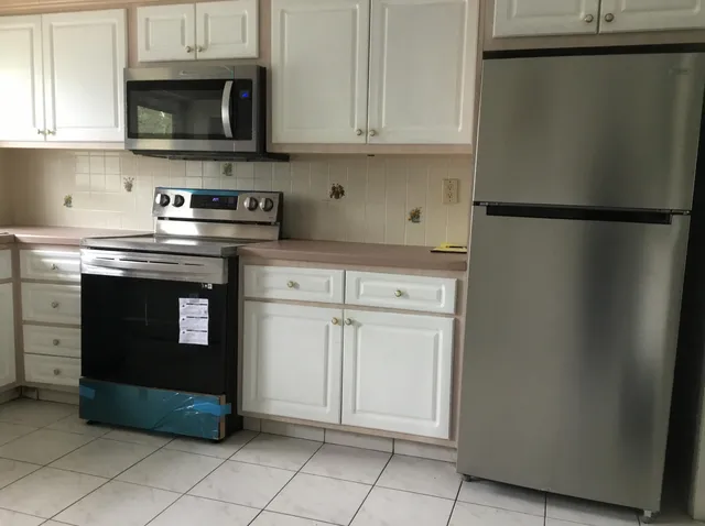 a kitchen with stainless steel appliances granite countertop a stove a sink and a microwave