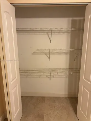 a view of walk in closet with window and wooden floor