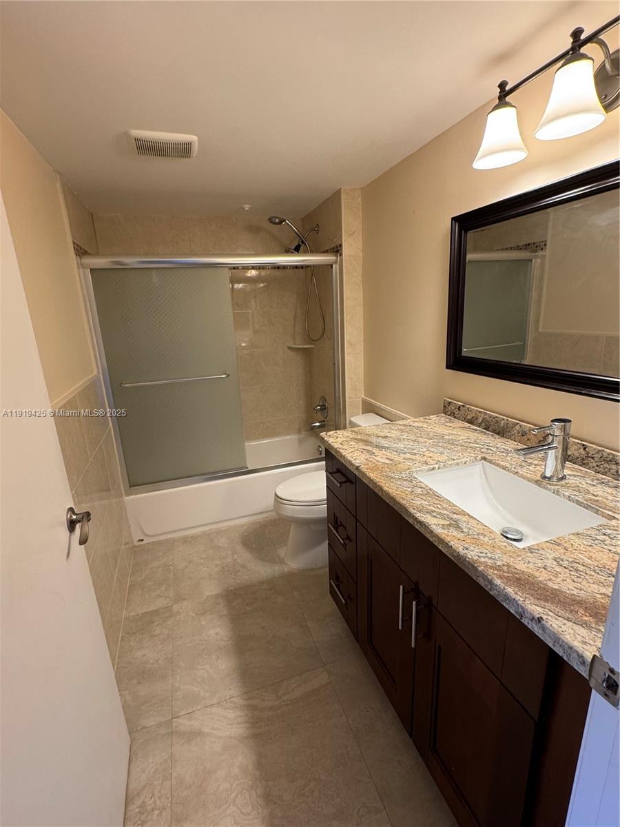 1001 Southwest 141st Avenue, Unit 107K Pembroke Pines, FL 33027 - Photo 12 of 28 a bathroom with a granite countertop sink a mirror and shower