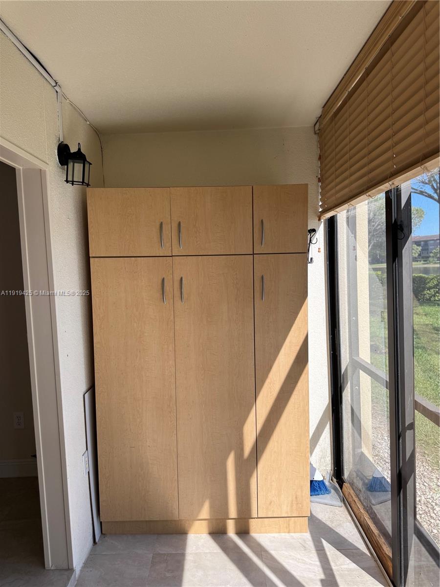 1001 Southwest 141st Avenue, Unit 107K Pembroke Pines, FL 33027 - Photo 14 of 28 a view of walk in closet with window and wooden floor