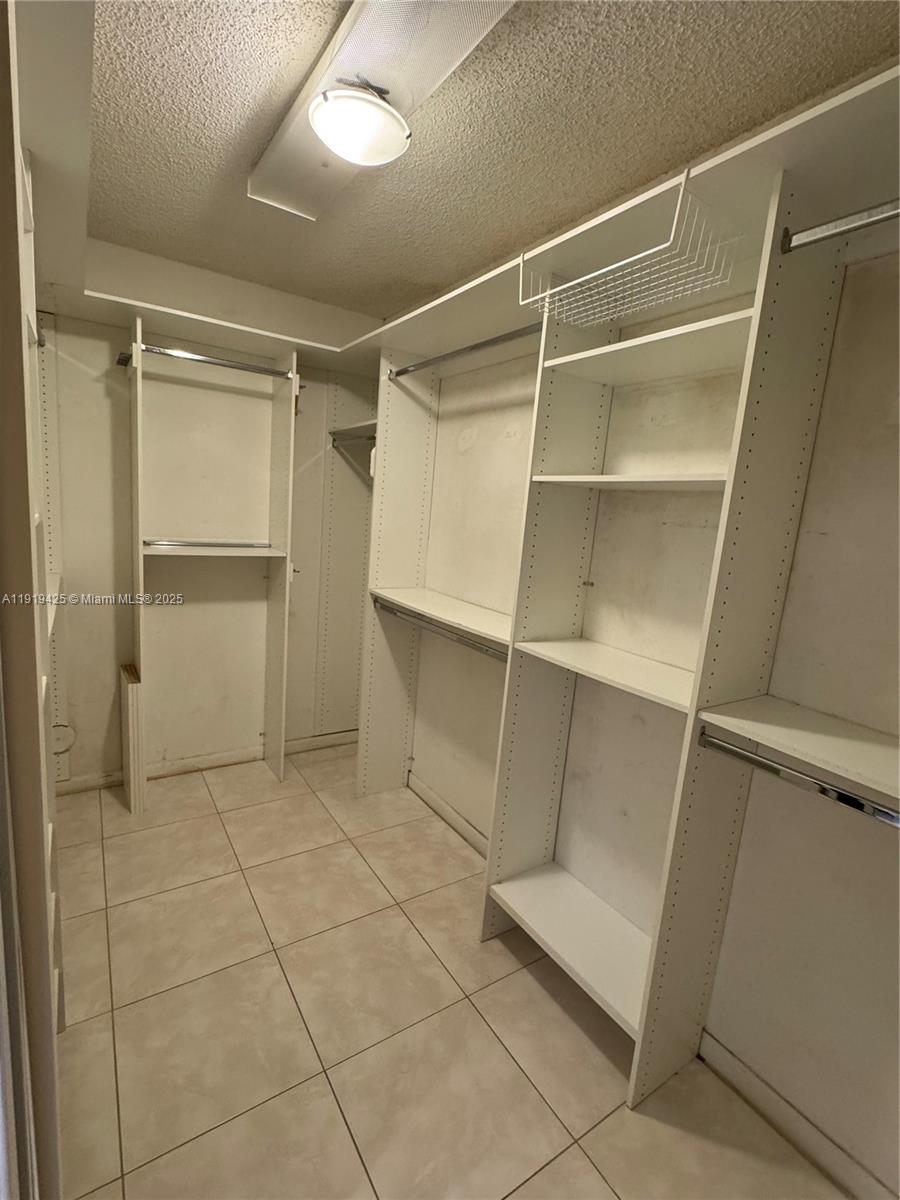1001 Southwest 141st Avenue, Unit 107K Pembroke Pines, FL 33027 - Photo 18 of 28 a view of an empty walk in closet