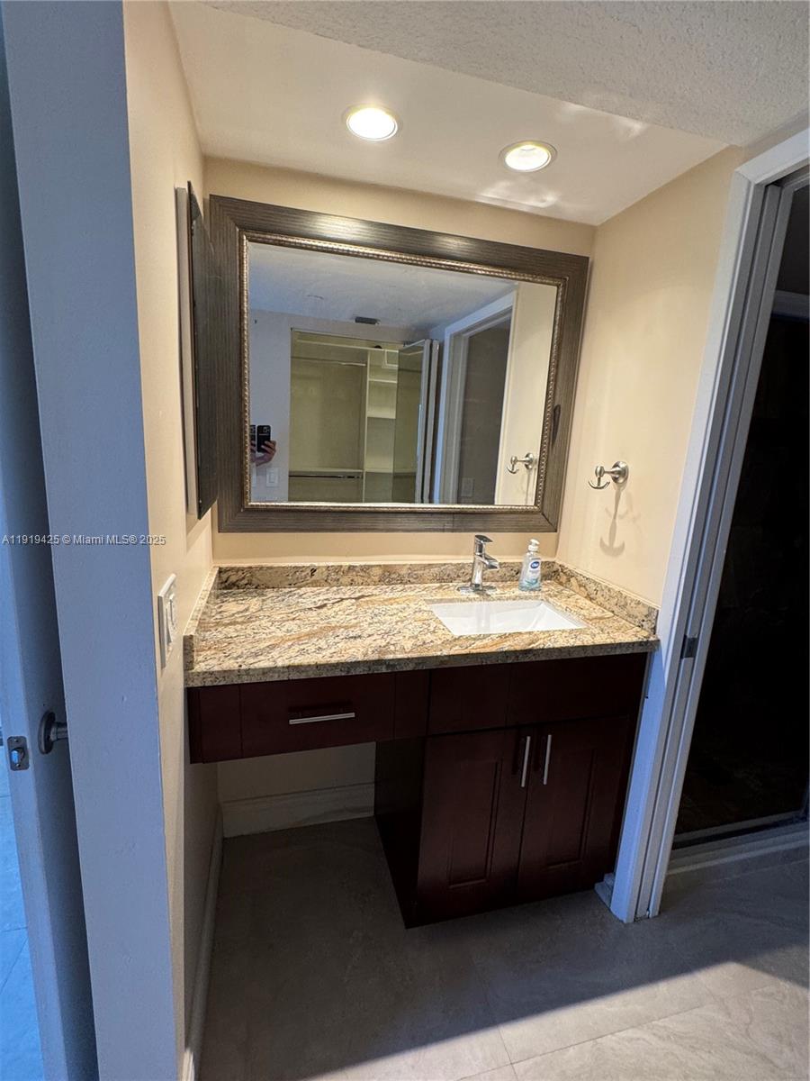 1001 Southwest 141st Avenue, Unit 107K Pembroke Pines, FL 33027 - Photo 21 of 28 a bathroom with a sink and a mirror