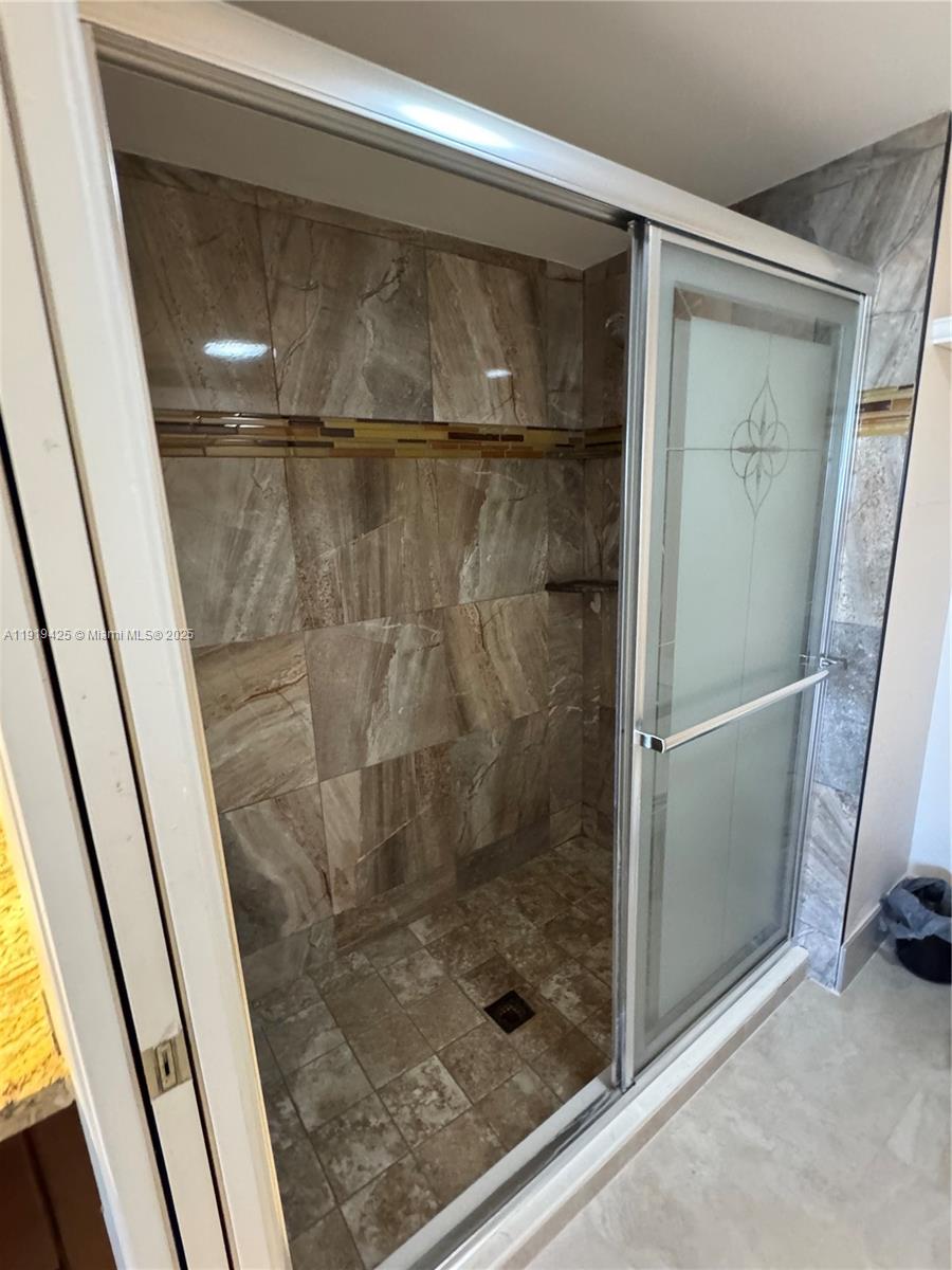 1001 Southwest 141st Avenue, Unit 107K Pembroke Pines, FL 33027 - Photo 22 of 28 a bathroom with a glass door shower