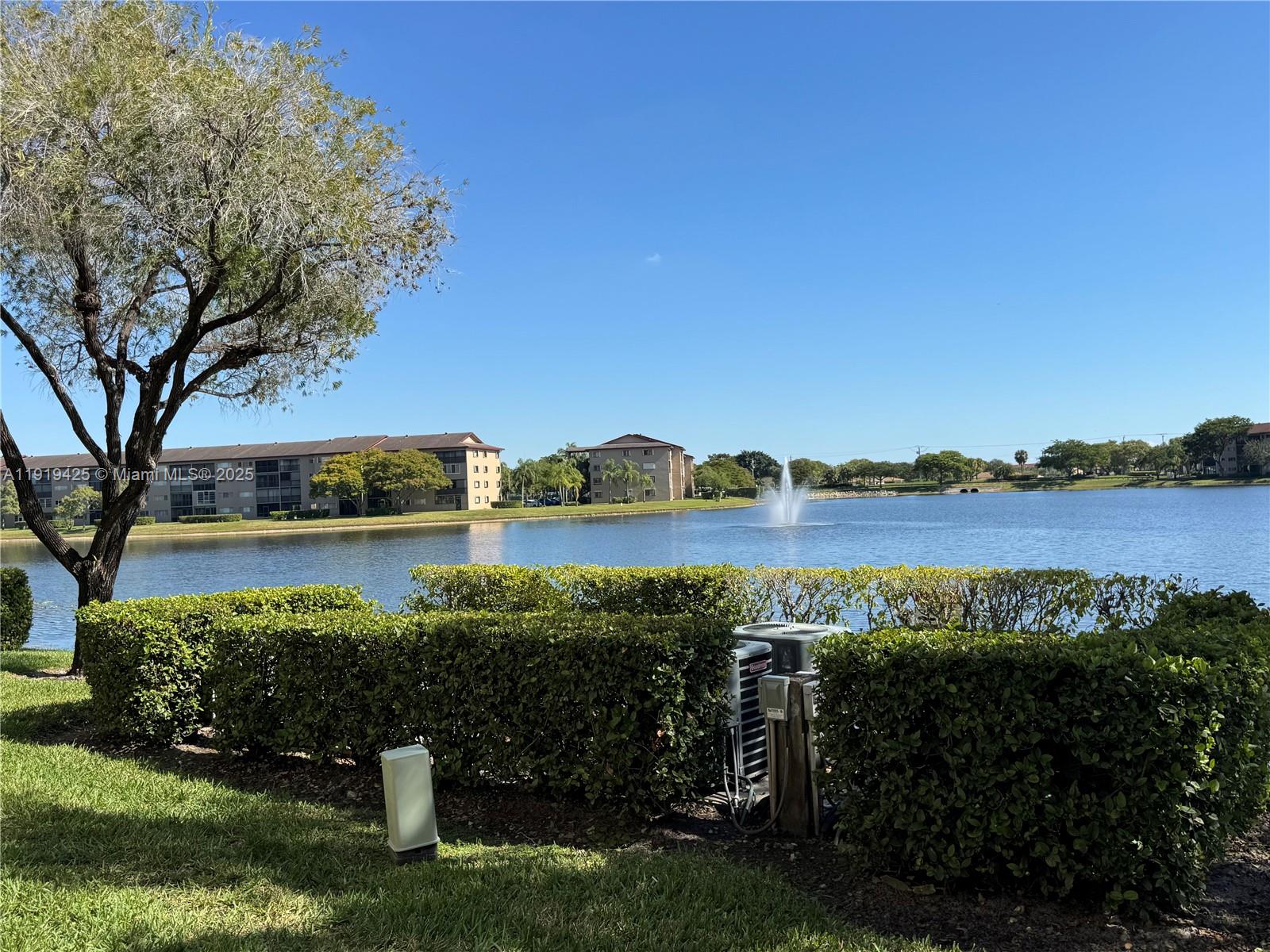 1001 Southwest 141st Avenue, Unit 107K Pembroke Pines, FL 33027 - Photo 27 of 28 a view of a lake with a house in the background