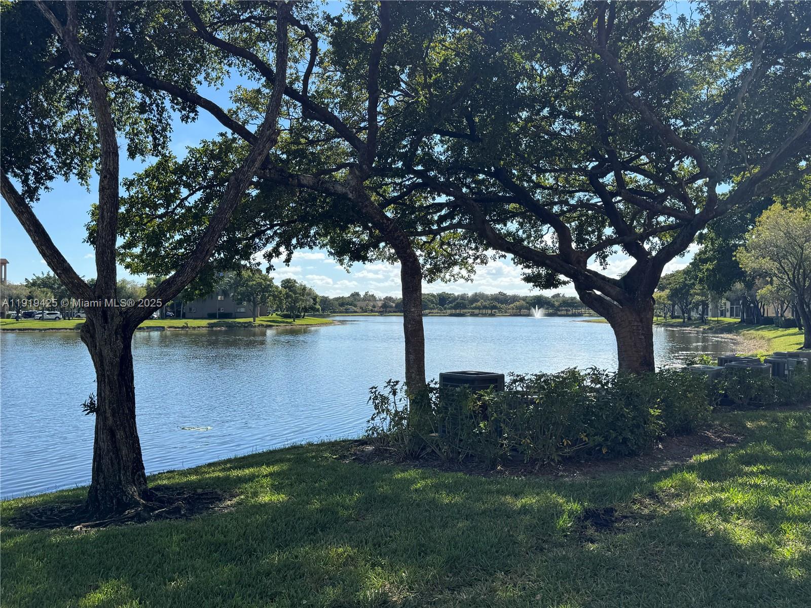 1001 Southwest 141st Avenue, Unit 107K Pembroke Pines, FL 33027 - Photo 28 of 28 a view of a lake with a yard and large trees