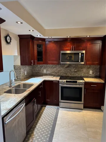 a kitchen with stainless steel appliances a sink a microwave a stove and refrigerator
