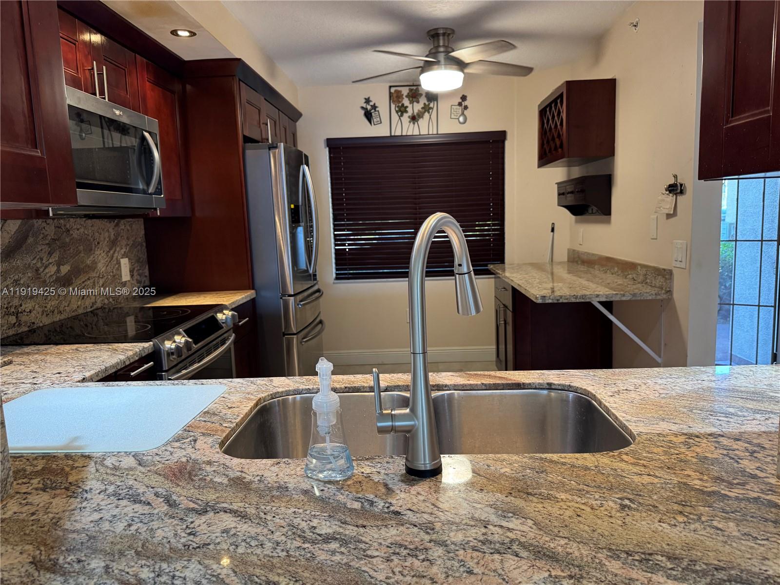 1001 Southwest 141st Avenue, Unit 107K Pembroke Pines, FL 33027 - Photo 8 of 28 a kitchen with stainless steel appliances a sink a microwave a stove and refrigerator