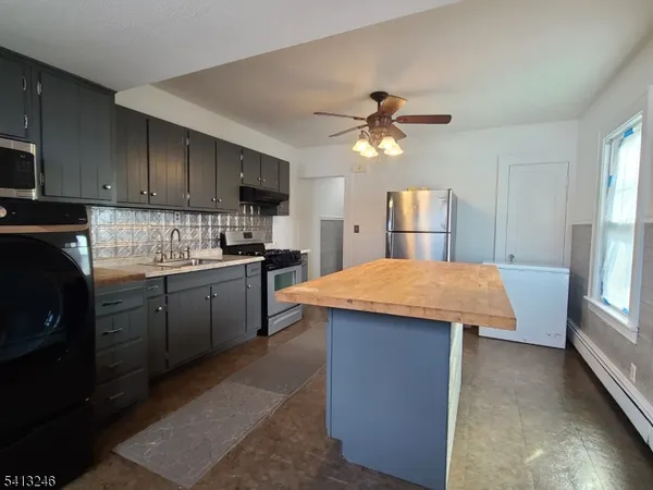 a kitchen with stainless steel appliances kitchen island granite countertop a stove a sink dishwasher and a refrigerator with wooden cabinets