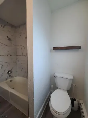 a white toilet sitting next to a bath tub