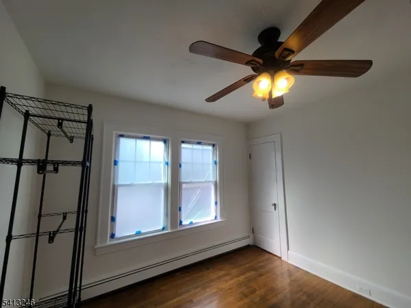 an empty room with windows and fan chandelier