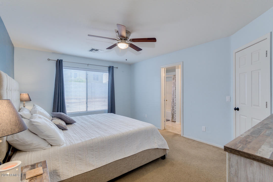 12714 West Calavar Road El Mirage, AZ 85335 - Photo 11 of 24 a bedroom with a bed and a window